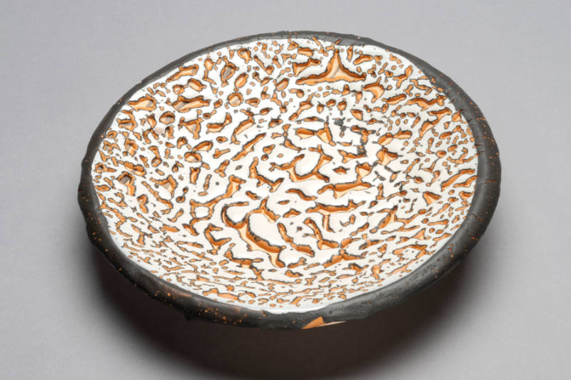 ROUND BLACK, ORANGE, WHITE MOTTLED WALL PLATE